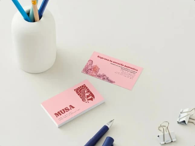 Tarjetas de presentación MUSA en tono rosa sobre un escritorio claro